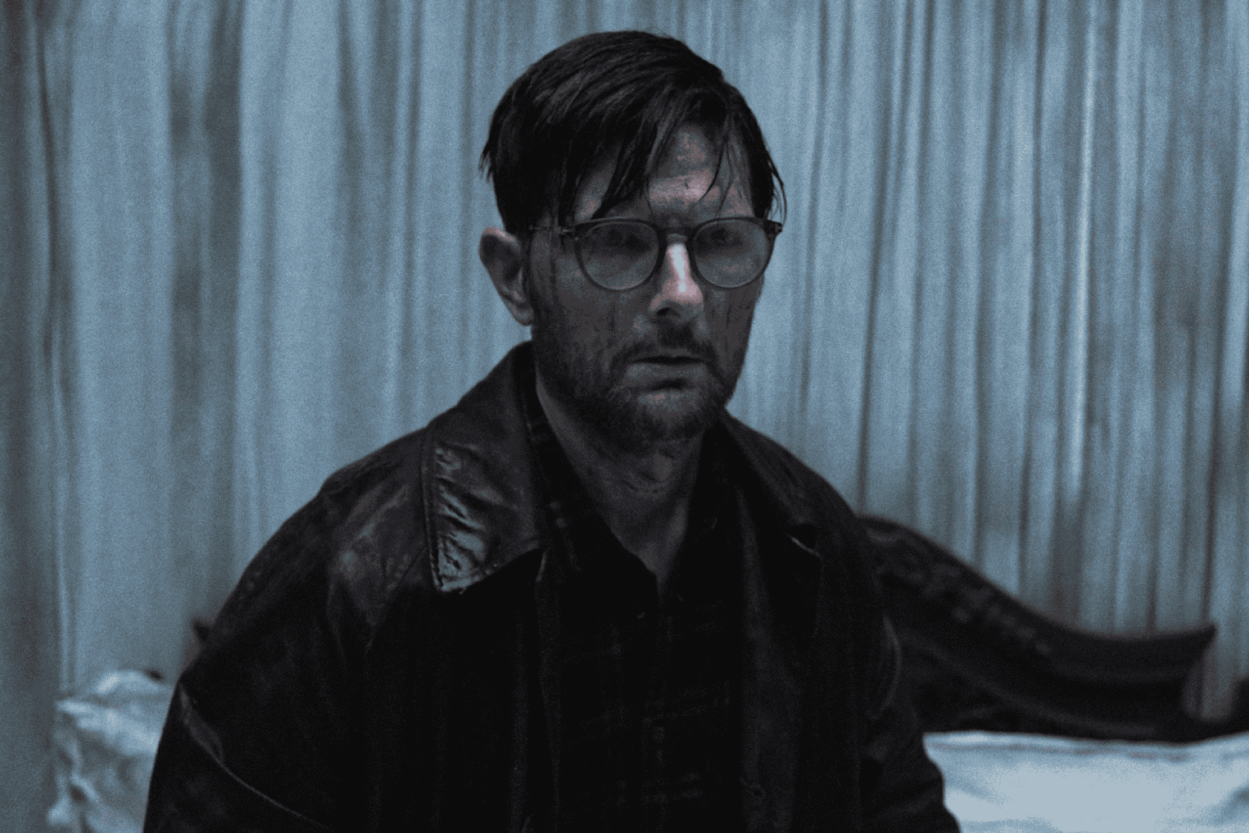 Promotional image of Hokum, featuring Adam Scott's Ohm Bauman dirty with some kind of liquid.